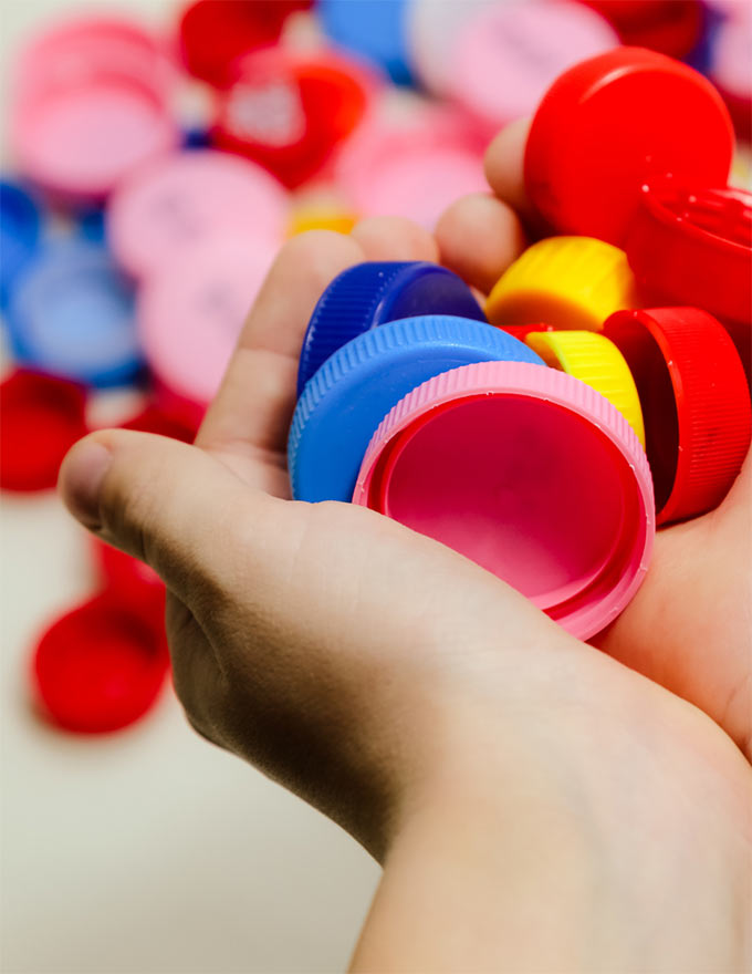 Photo de bouchons en plastique posés dans des mains