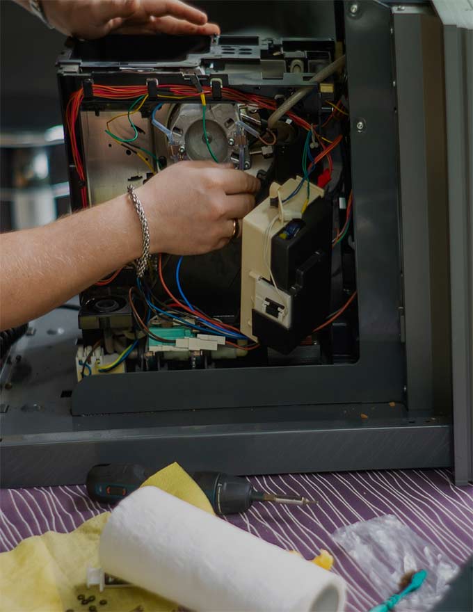 Photo d'une personne qui répare le composant électronique d'un appareil