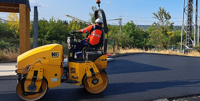 Photo lors des travaux de la déchèterie d'un ouvrier lissant le béton pour la partie route